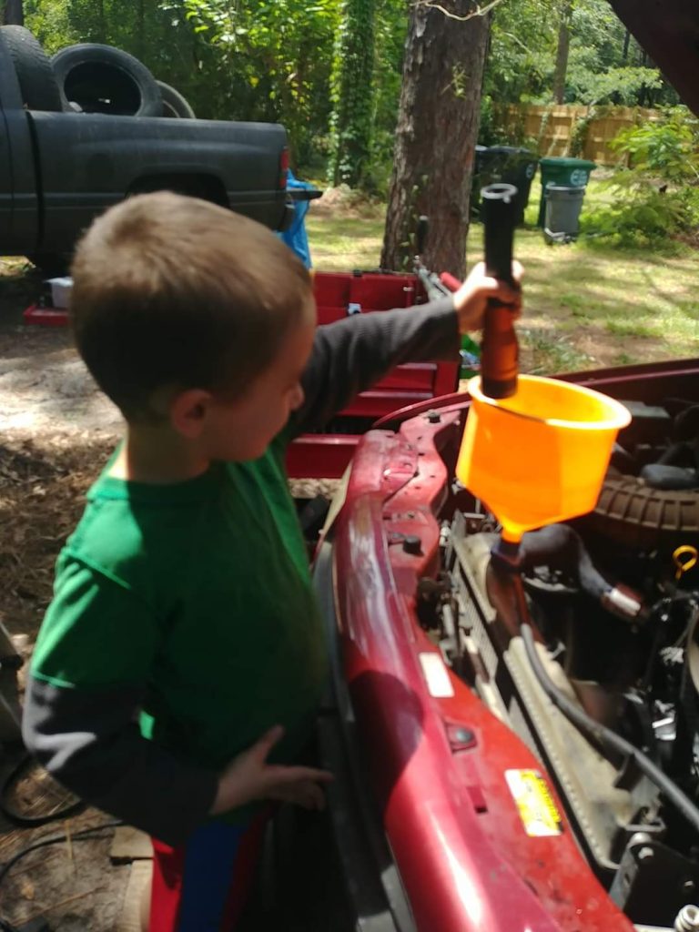 Joey Harris teaching his son some basic auto maintainance